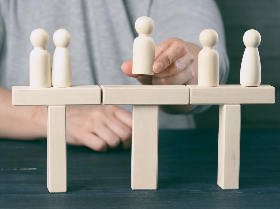 Resistencia al cambio claves para transformar - Figura moviendo piezas de madera que representan personas.